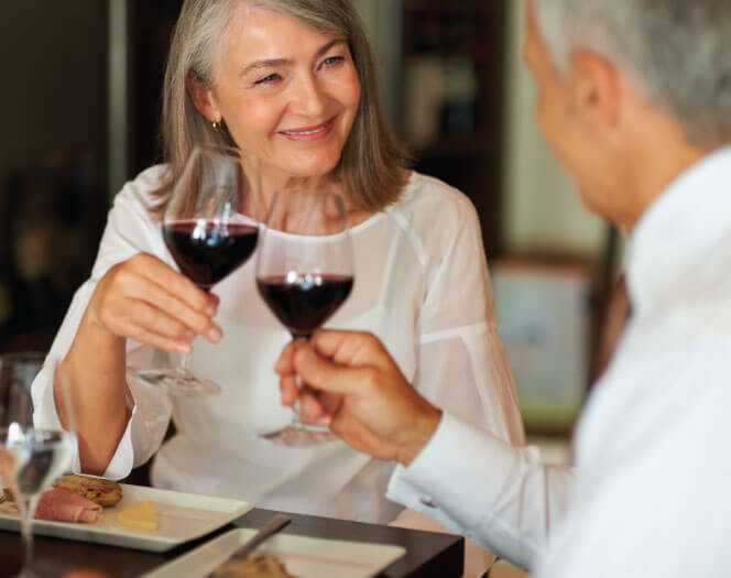 senior woman drinking wine with her husband