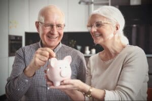 senior couple saving money in a piggy bank
