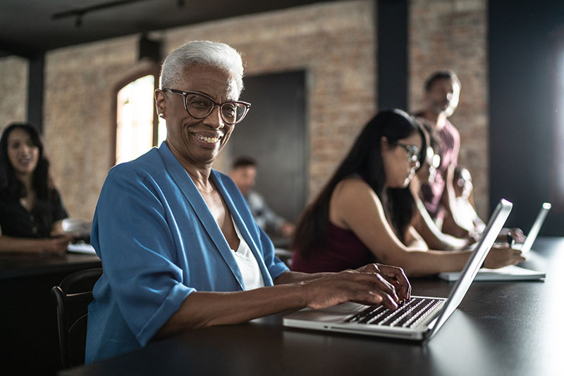 senior woman smiling at a laptop