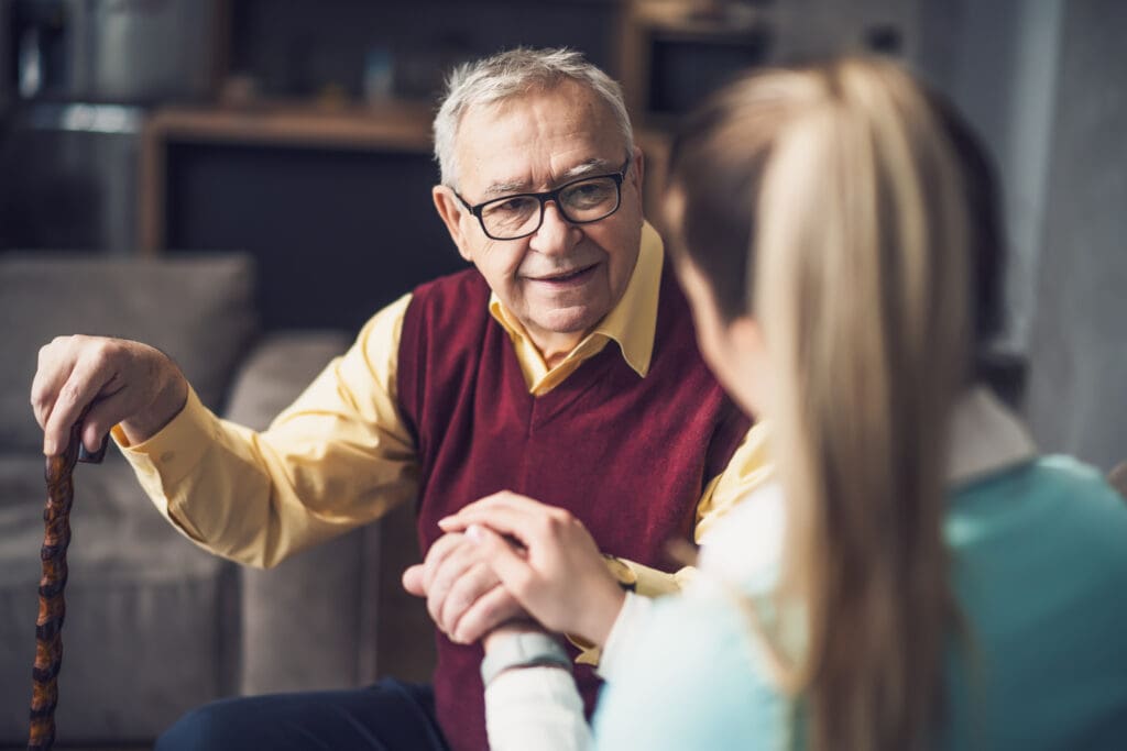 Home doctor is visiting senior man to check his health. Professional caregiver is assisting old man at his home while moving from assisted living to memory care at The Delaney at The Green.