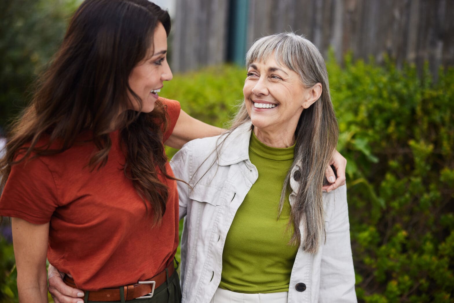 Senior woman and adult woman smiling at each other