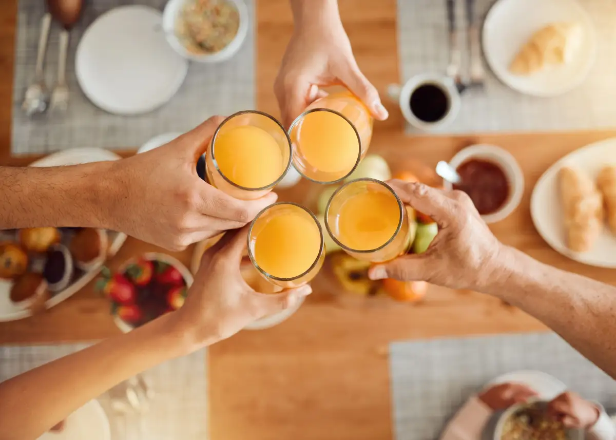 people toasting with glasses of mimosas