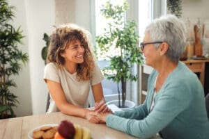 Young beautiful smiling woman bonding with her grandmother in a domestic kitchen