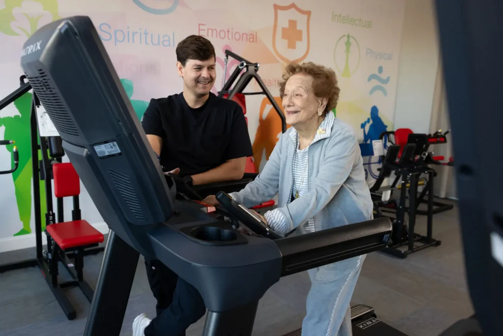 senior lady on treadmill next to a Delaney personal trainer