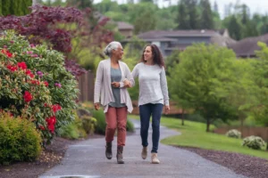 young adult woman walks arm in arm with elderly mom and talking about activities for seniors with dementia in Florham Park, NJ.