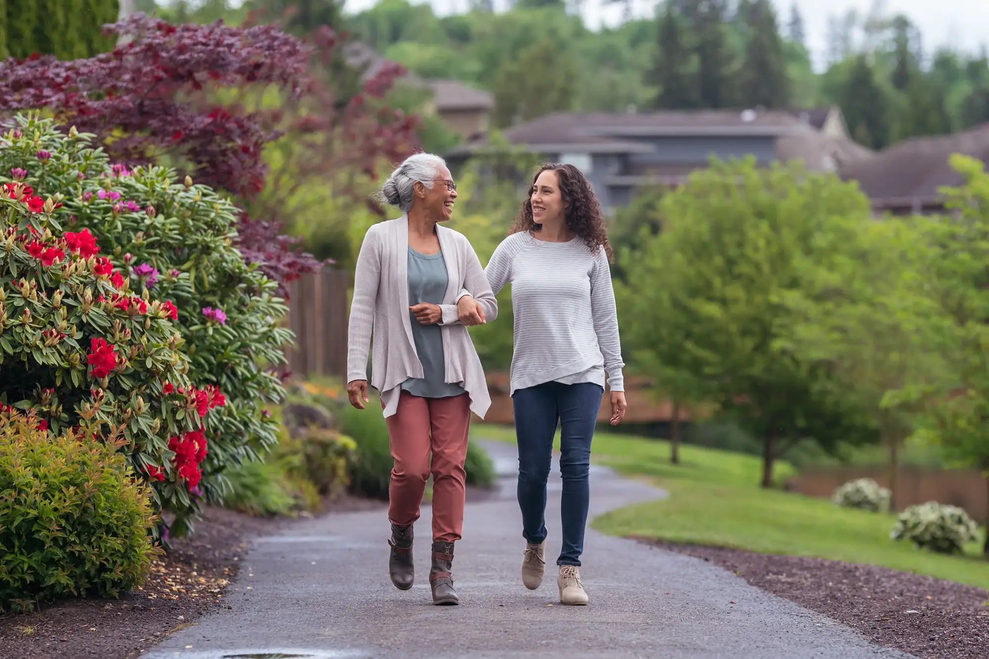 young adult woman walks arm in arm with elderly mom and talking about activities for seniors with dementia in Florham Park, NJ.